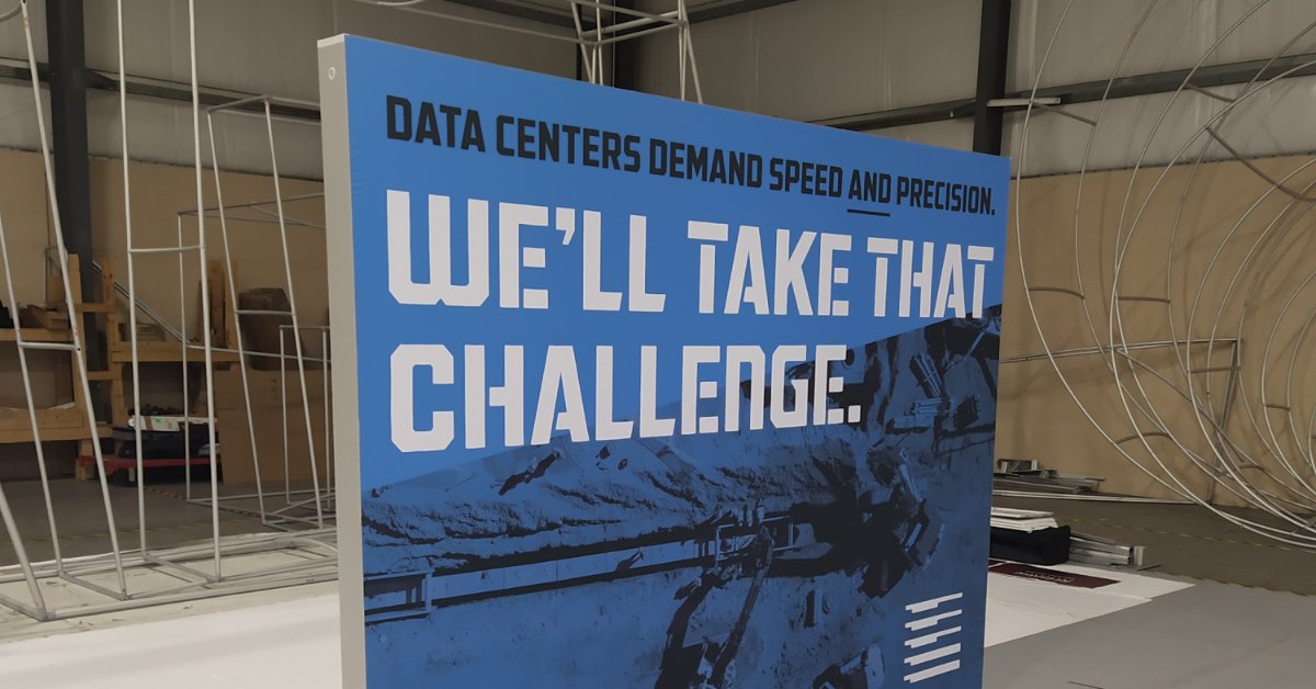 A trade show panel displaying the message "We'll Take That Challenge" for data center infrastructure solutions.